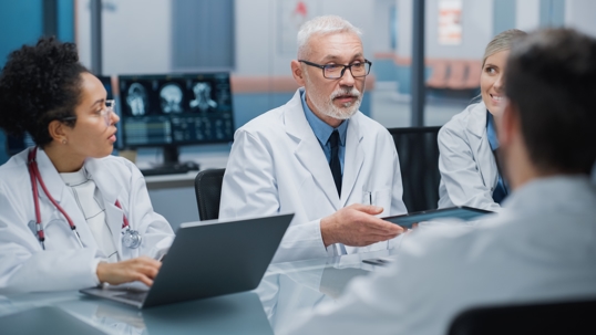 Doctors in lab coats at a table talking